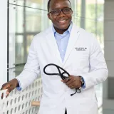 Dr. Job Mogire in his white cardiology coat, holding a stethoscope