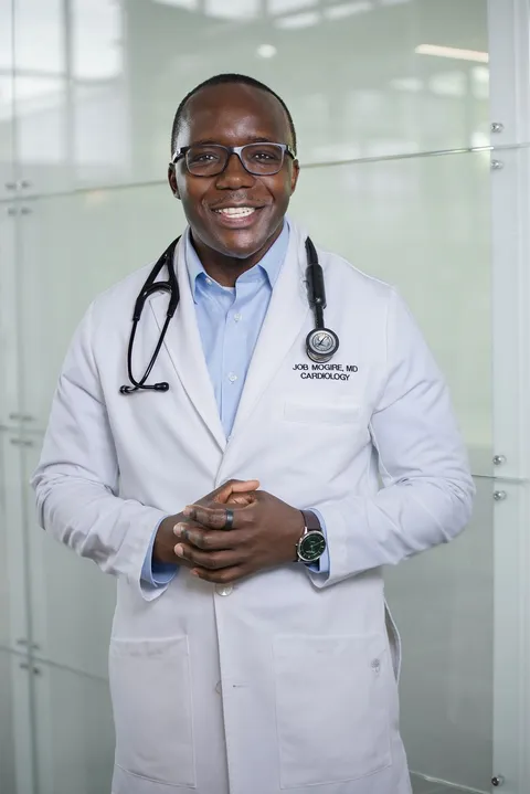 Dr. Job Mogire in his cardiology white coat at Carle Health